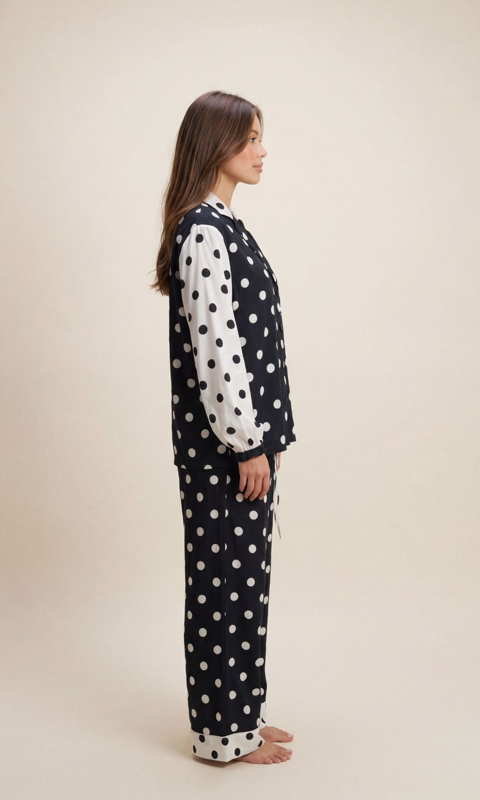 Woman wearing a polka dot pajama set on a beige background