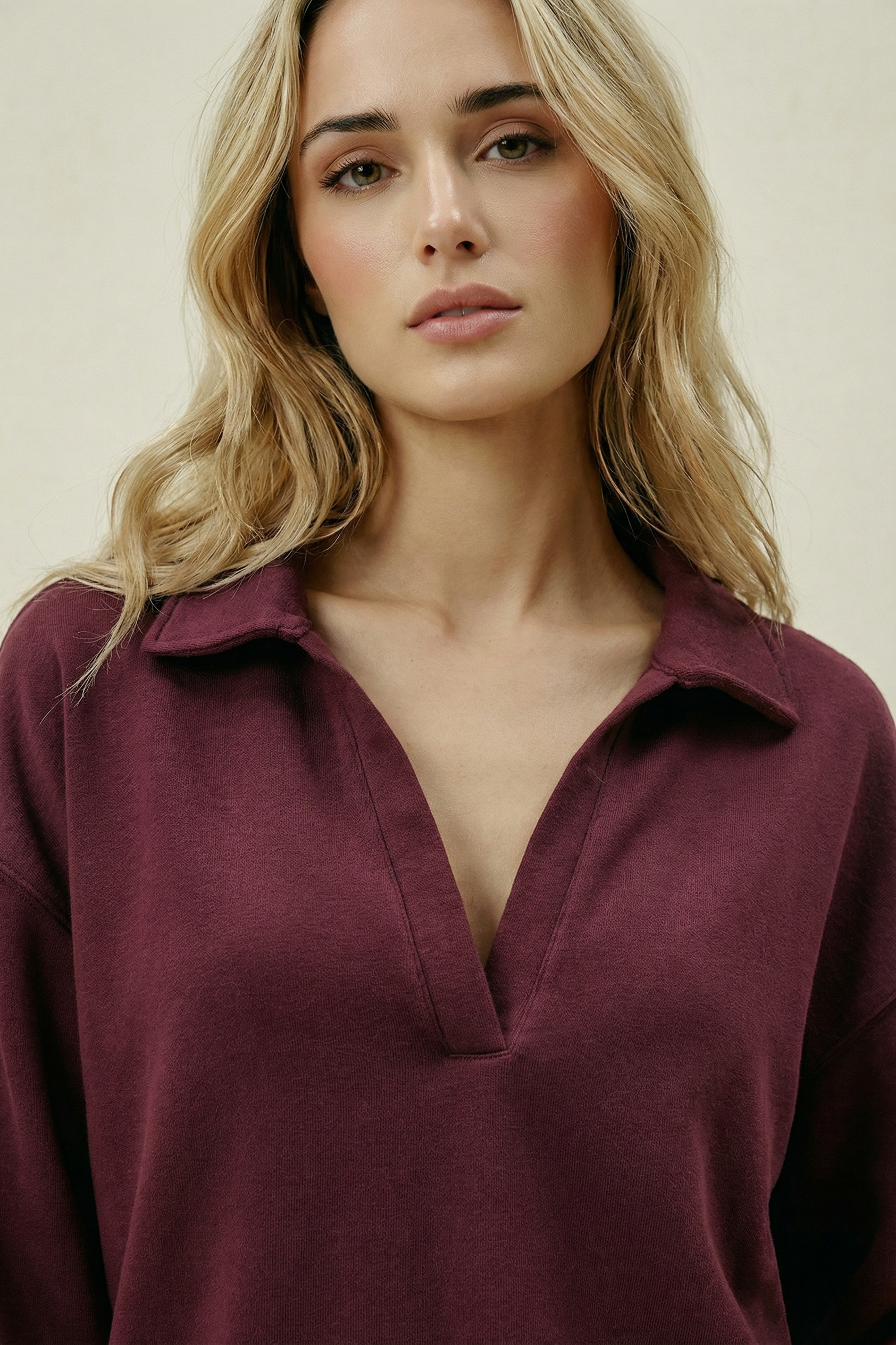 Woman wearing a burgundy shirt against a plain background