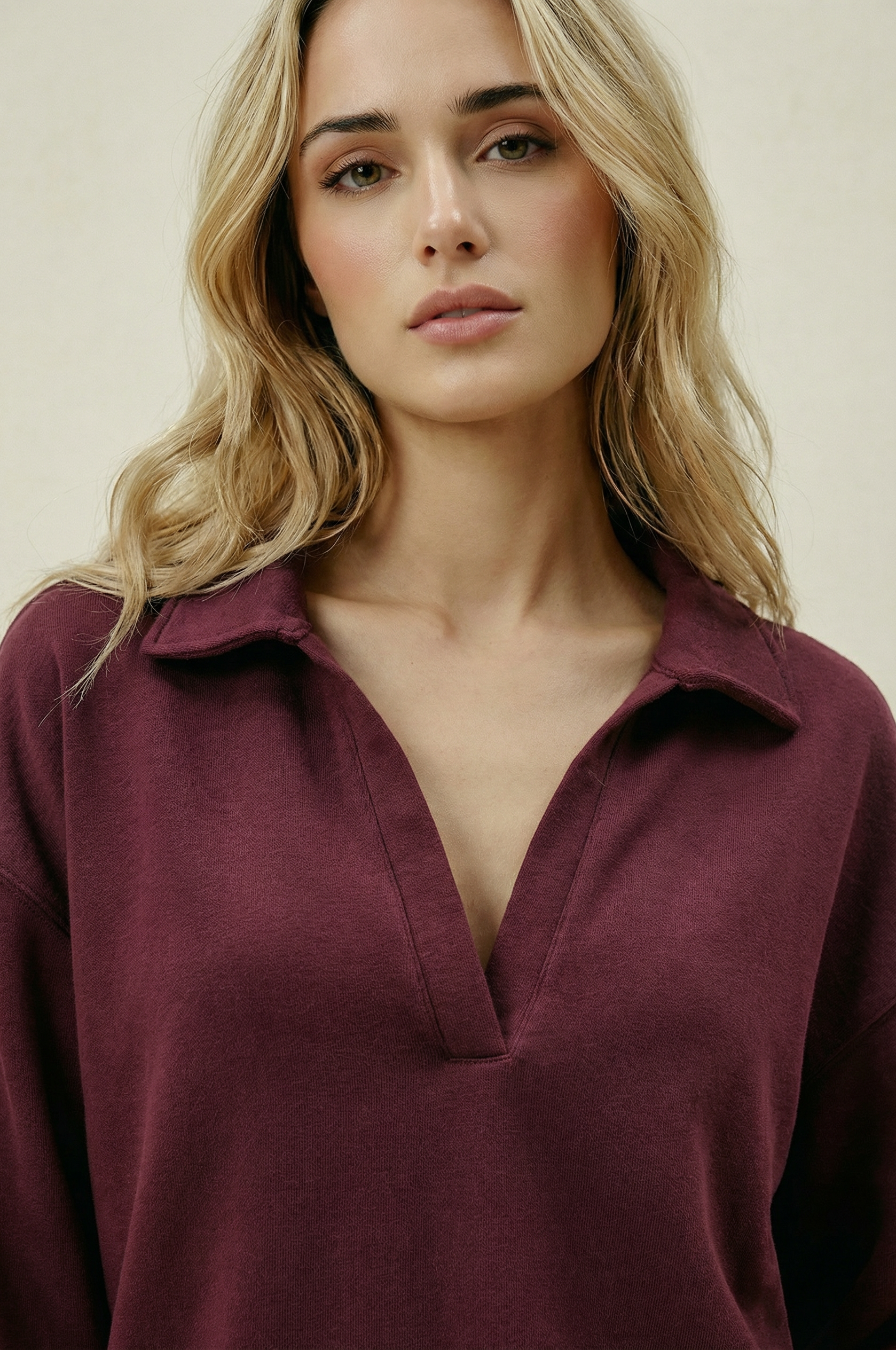Woman wearing a burgundy shirt against a plain background