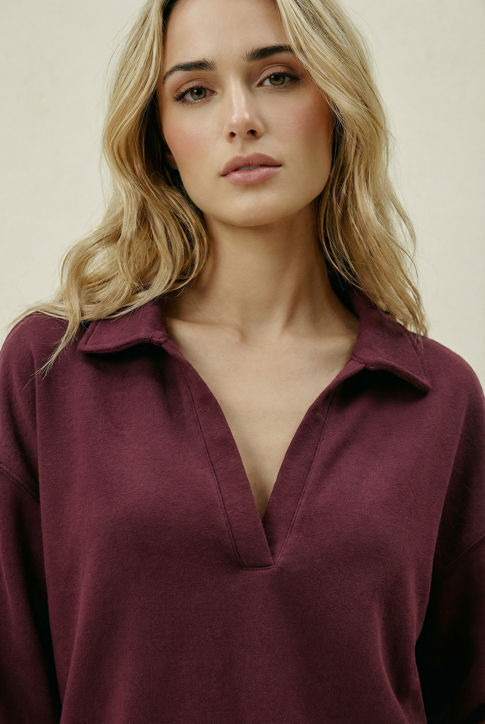 Woman wearing a burgundy shirt against a plain background