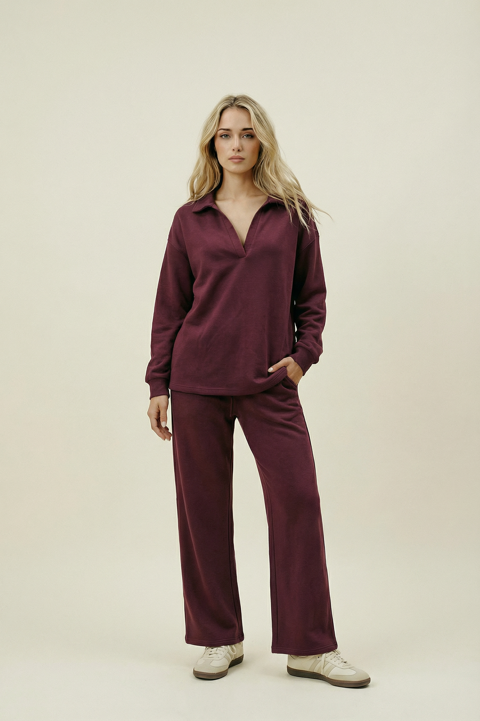 Woman wearing a burgundy outfit on a beige background