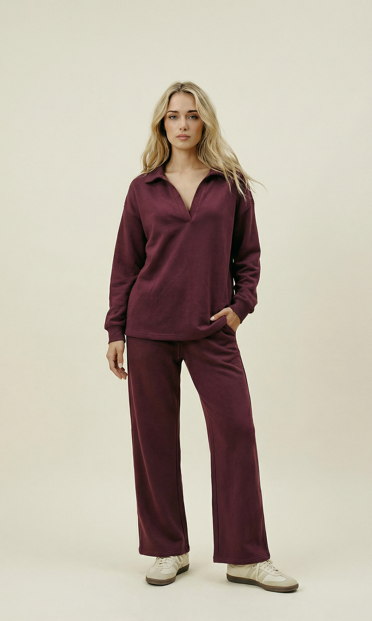 Woman wearing a burgundy outfit on a beige background