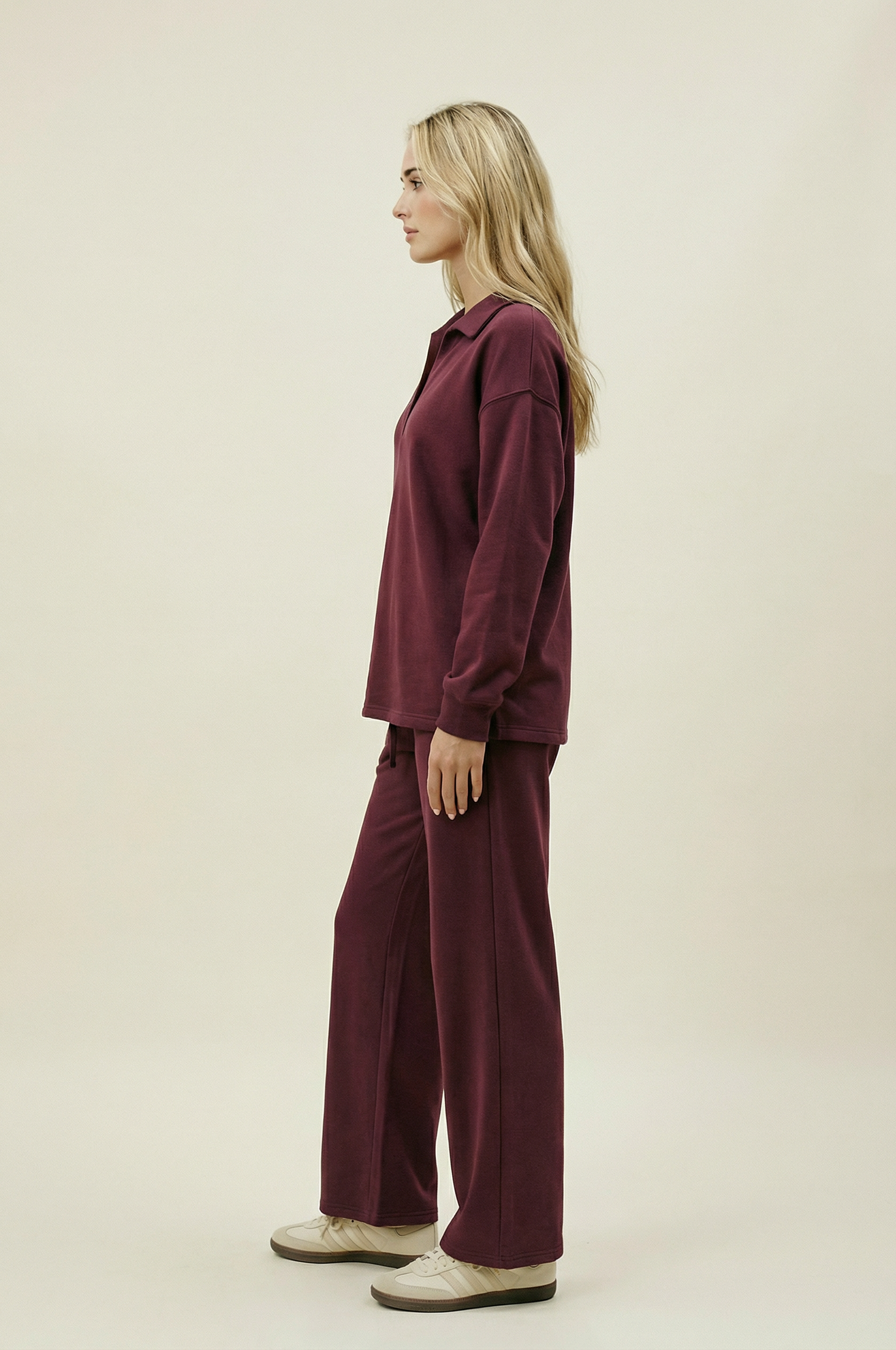Woman wearing a burgundy outfit on a beige background
