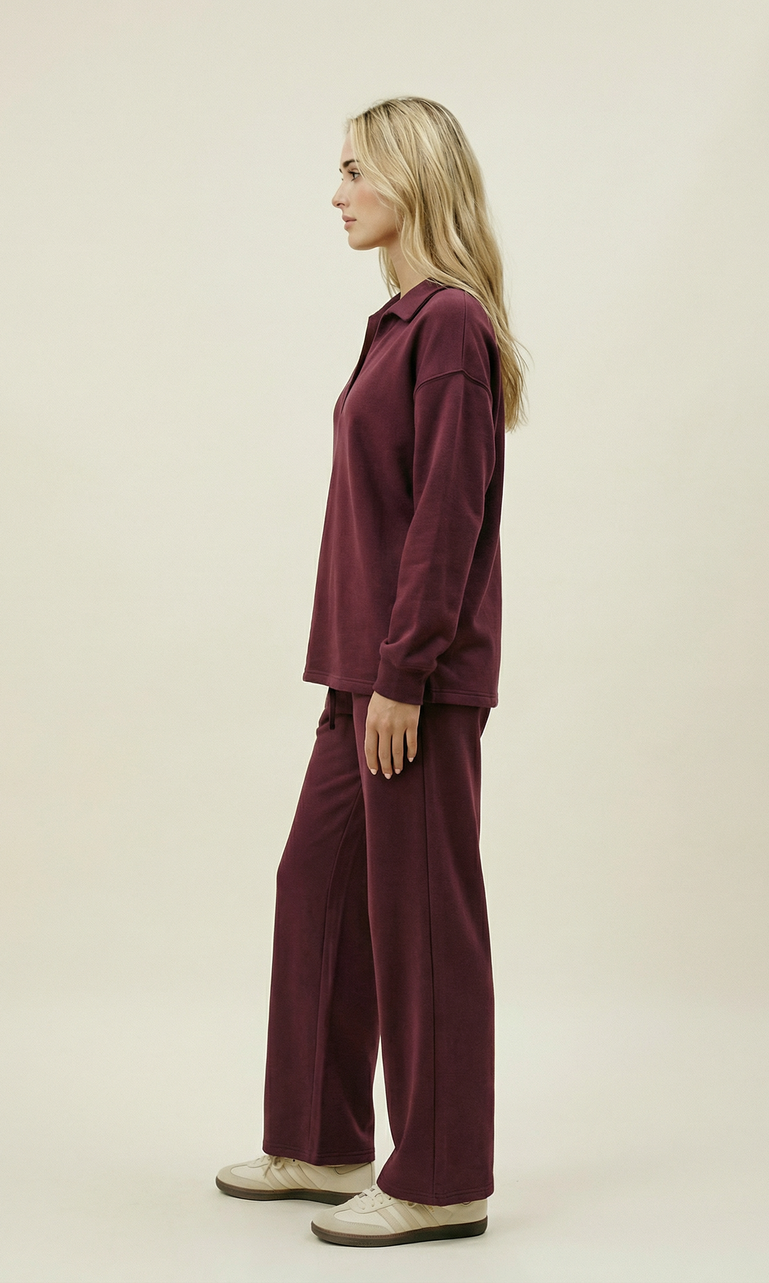 Woman wearing a burgundy outfit on a beige background