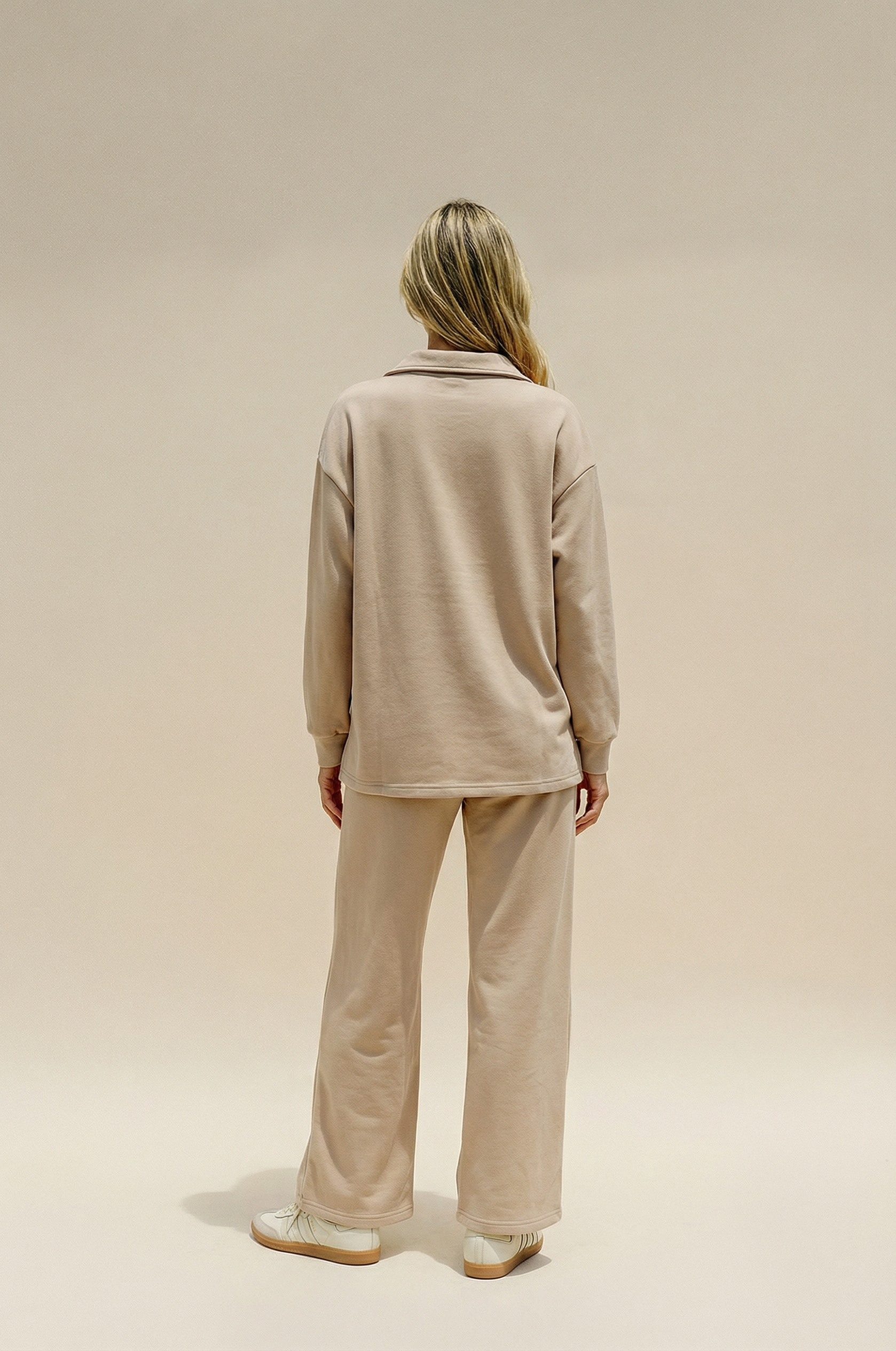 Person wearing a beige outfit on a plain background
