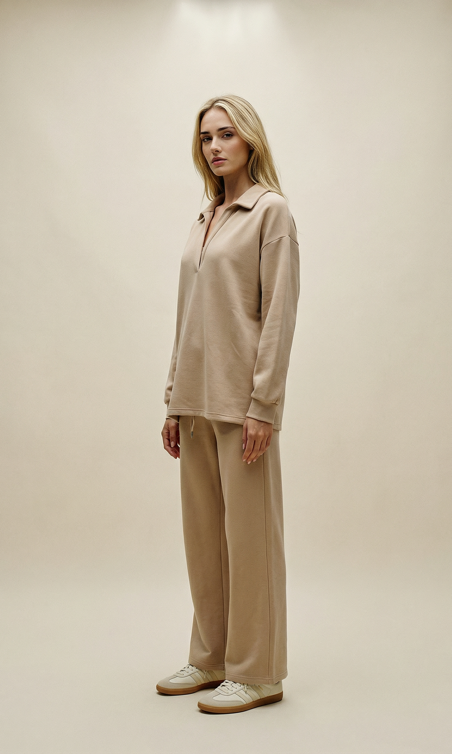 Woman wearing a beige outfit against a plain background