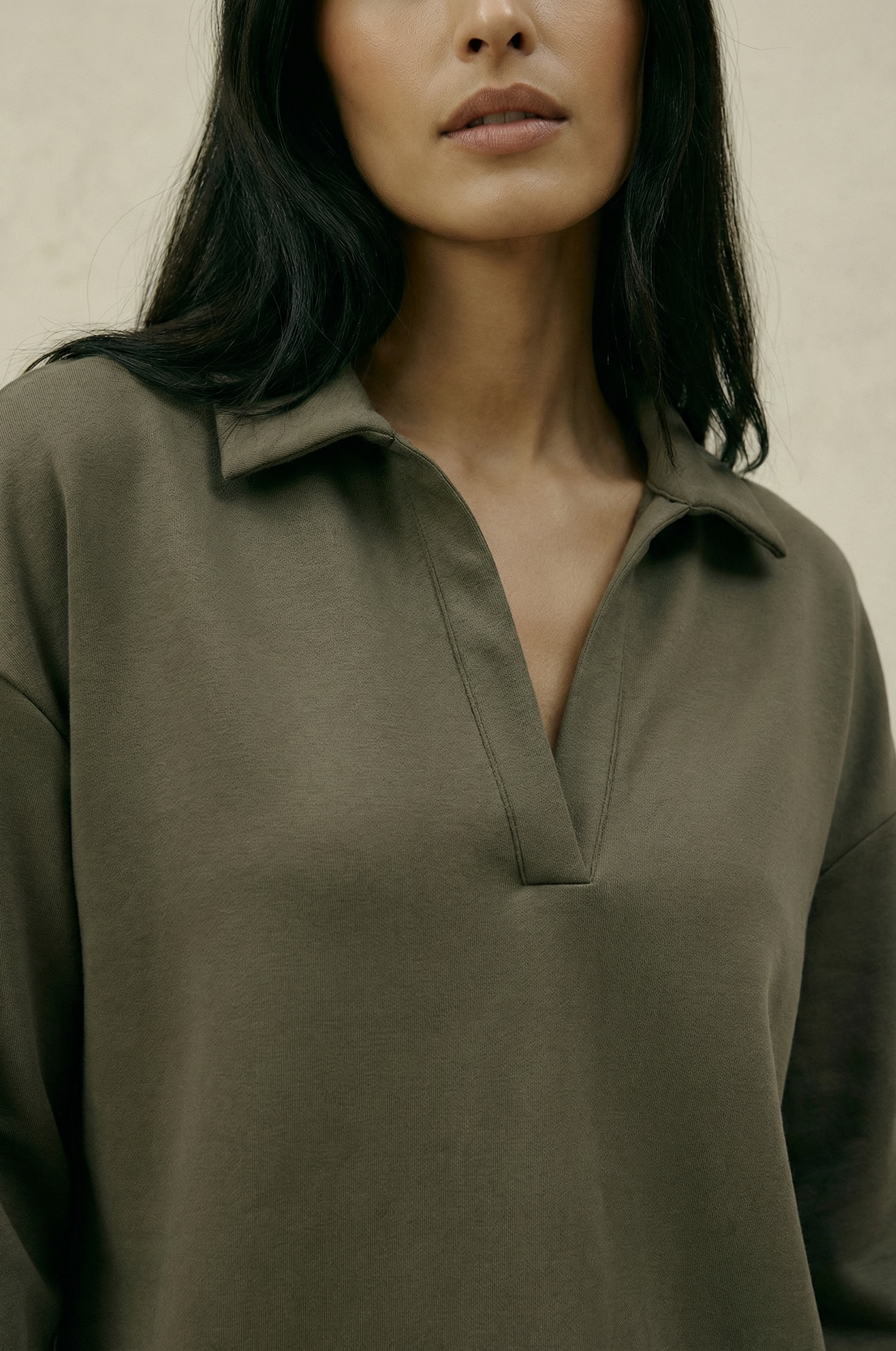 Woman wearing a green shirt against a neutral background