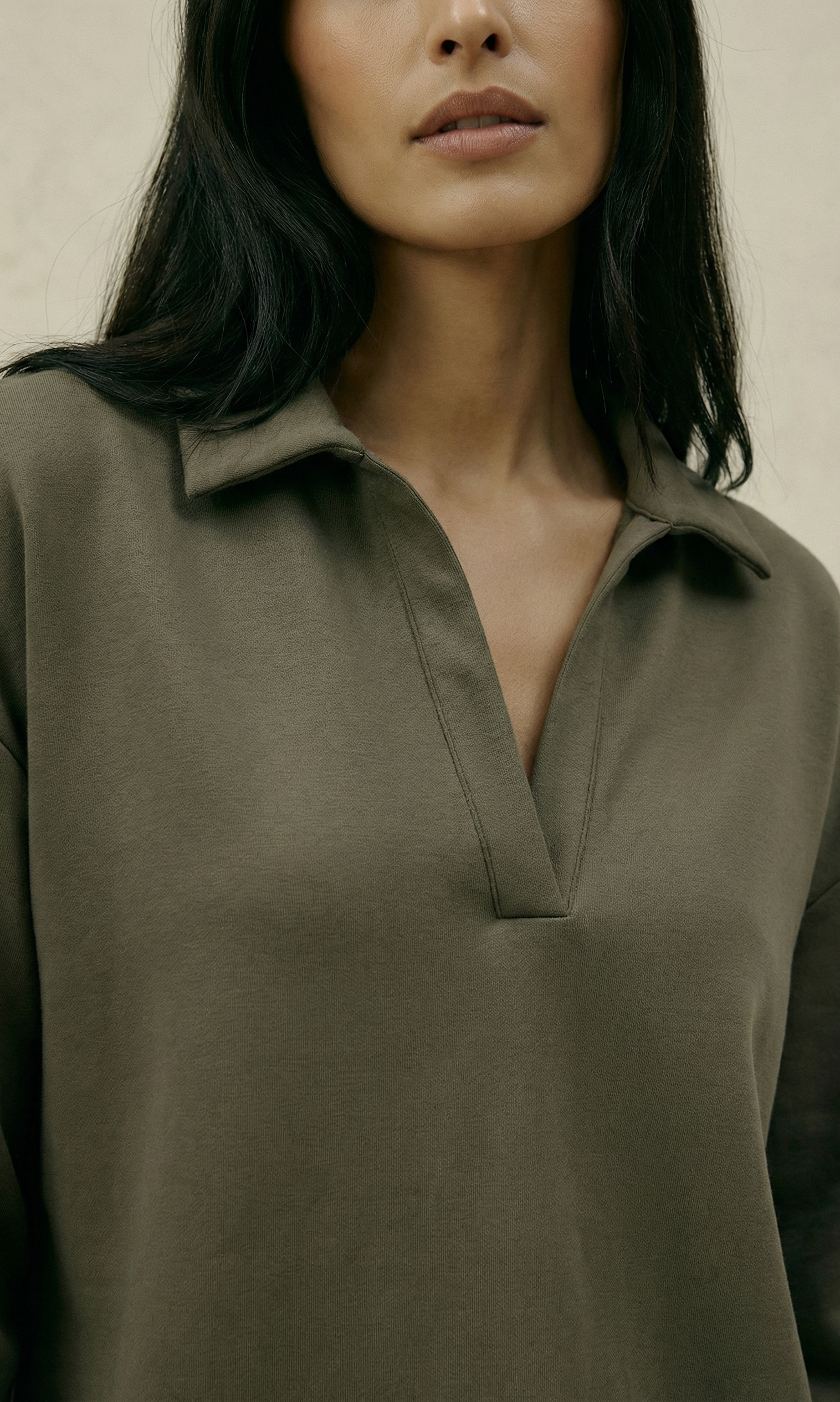 Woman wearing a green shirt against a neutral background