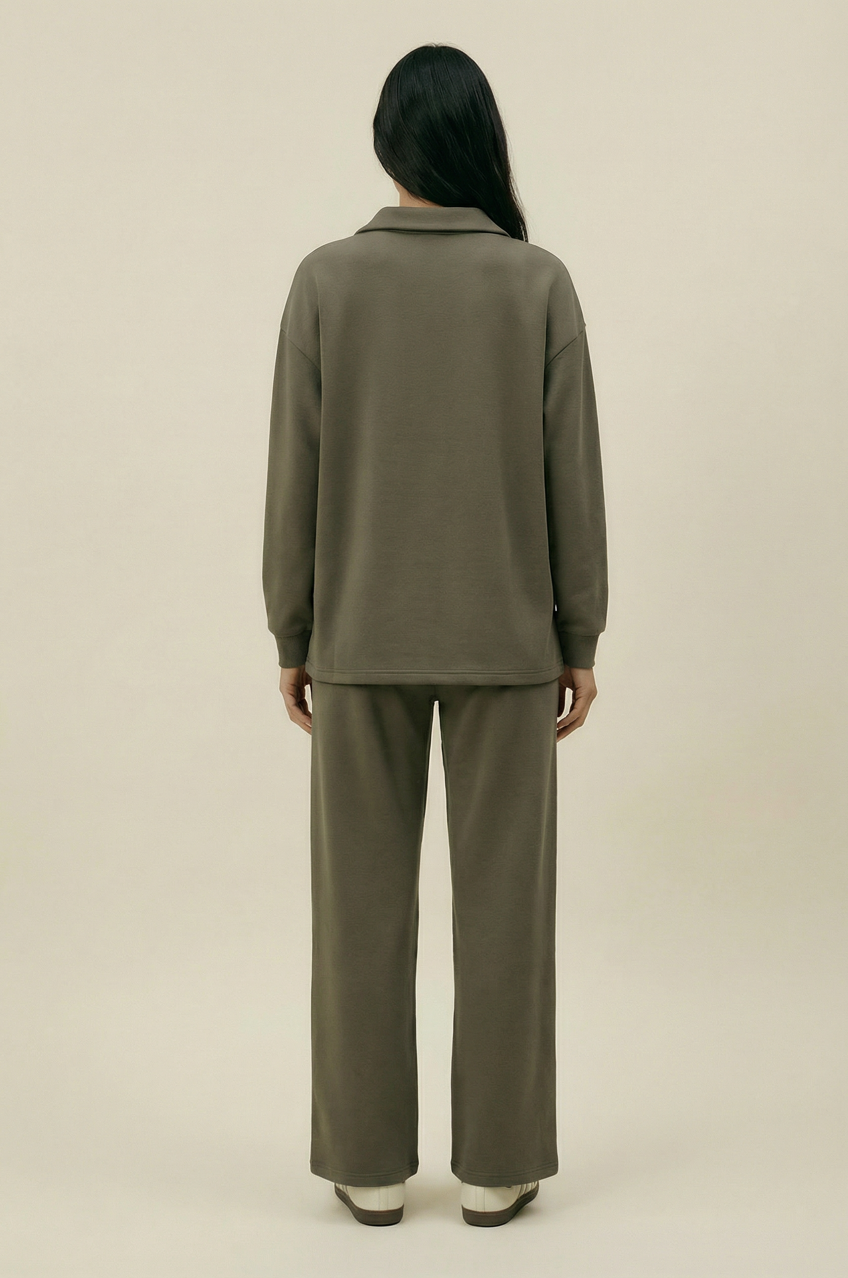 Person wearing a green outfit on a beige background
