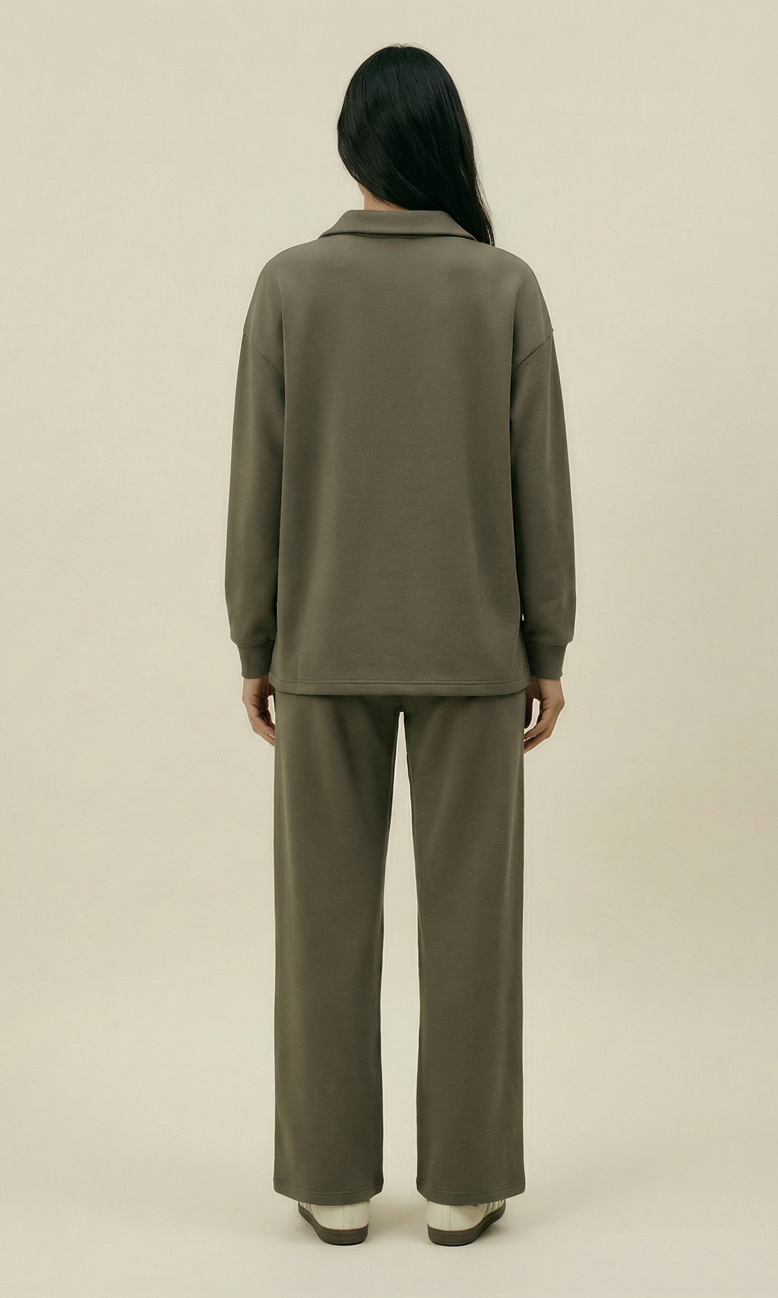 Person wearing a green outfit on a beige background