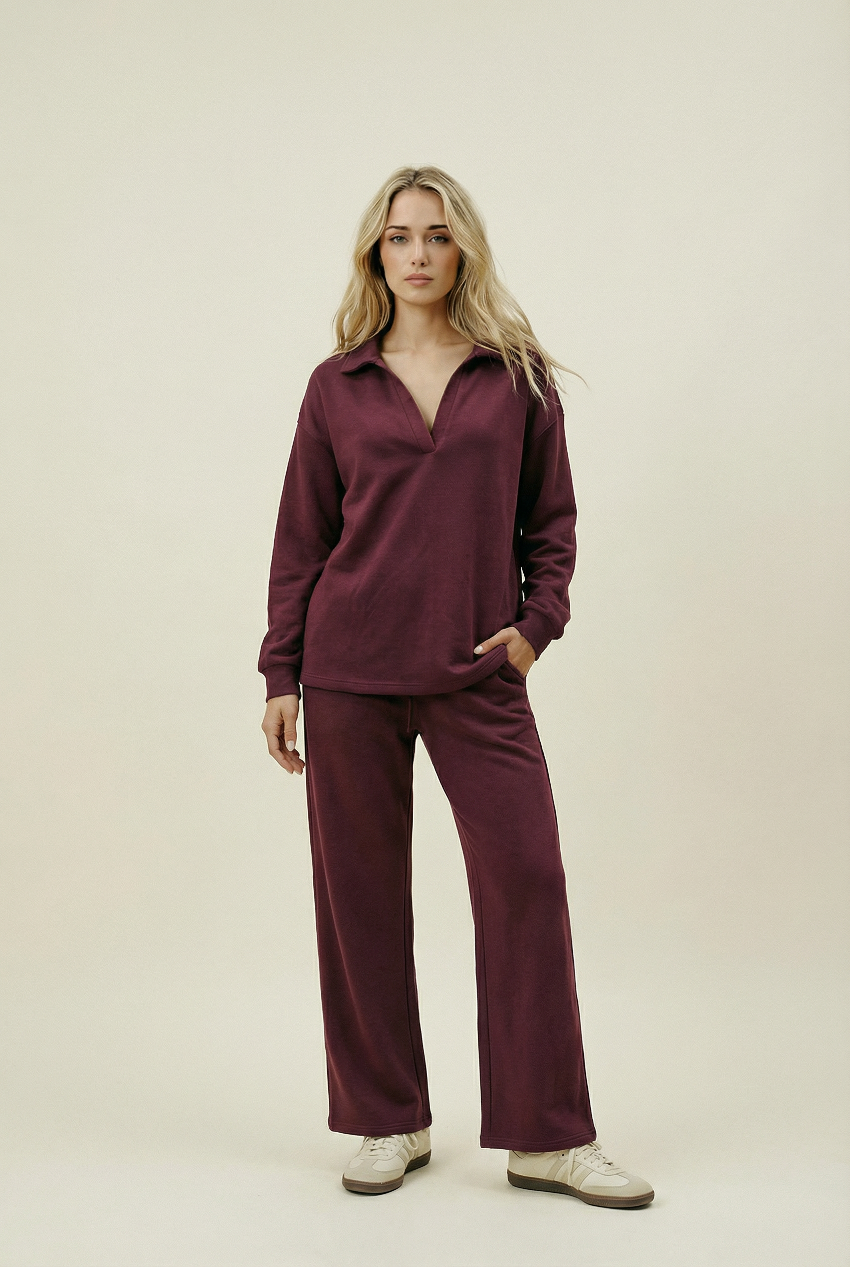 Woman wearing a burgundy outfit on a beige background