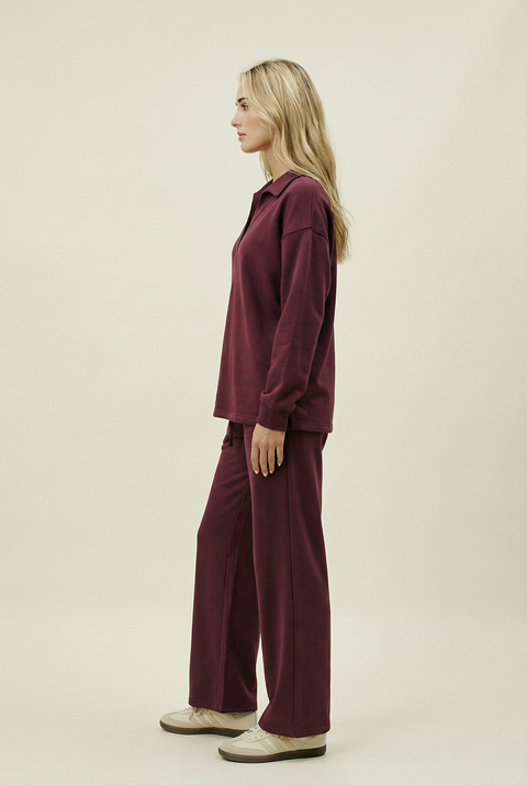 Woman wearing a burgundy outfit on a beige background