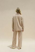 Person wearing a beige outfit on a plain background