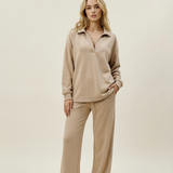 Woman wearing a beige outfit on a plain background