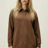 Woman wearing a brown long-sleeve shirt and pants on a beige background