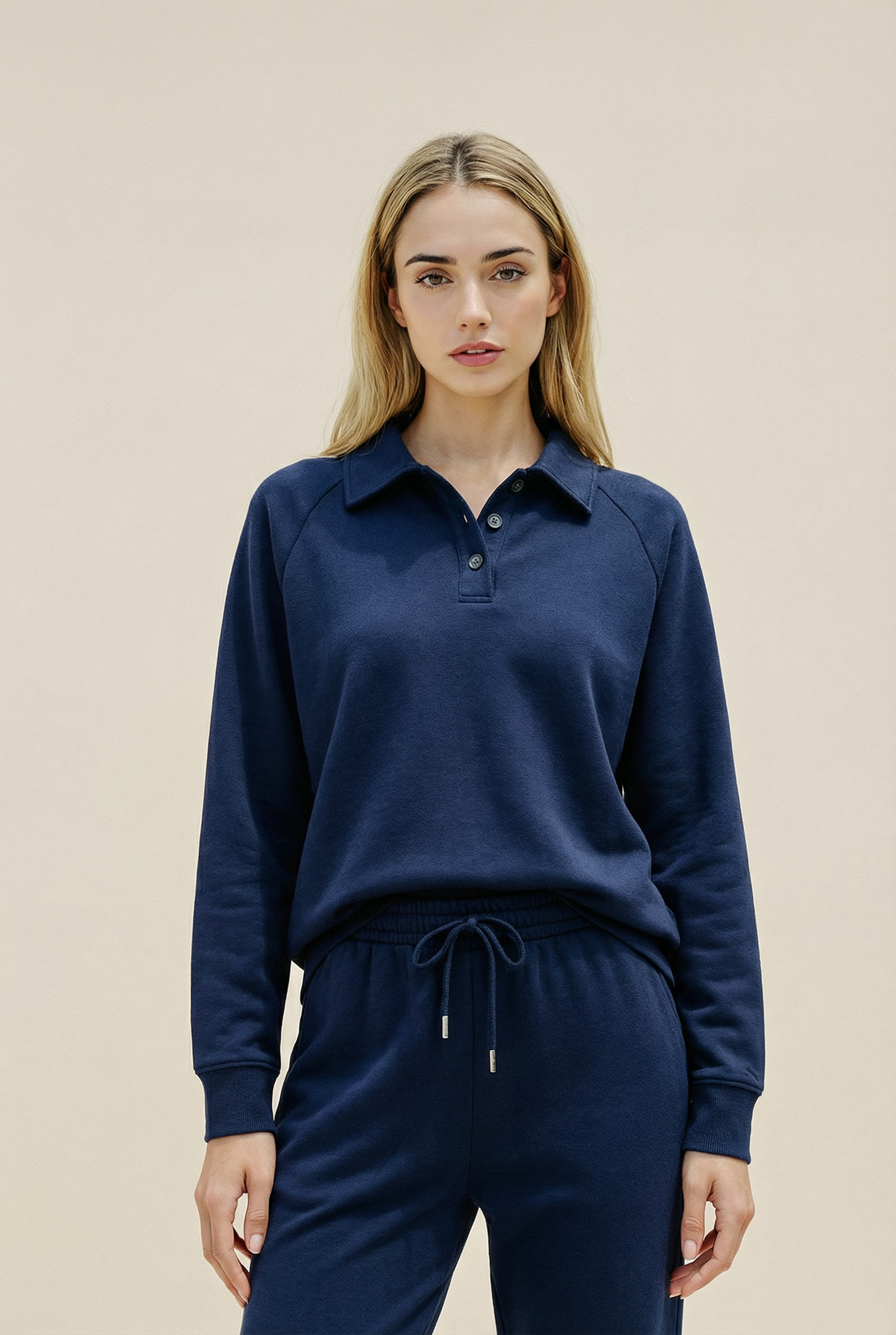 Woman wearing a navy blue long-sleeve shirt and matching pants against a beige background