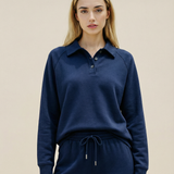Woman wearing a navy blue long-sleeve shirt and matching pants against a beige background