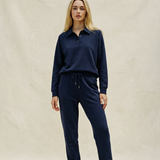 Woman wearing a navy blue outfit on a beige background