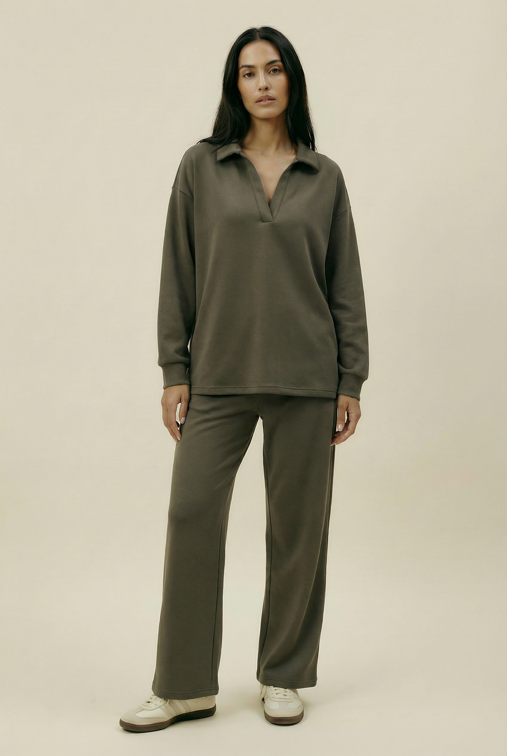 Woman wearing a green outfit on a beige background