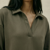 Woman wearing a green shirt against a neutral background