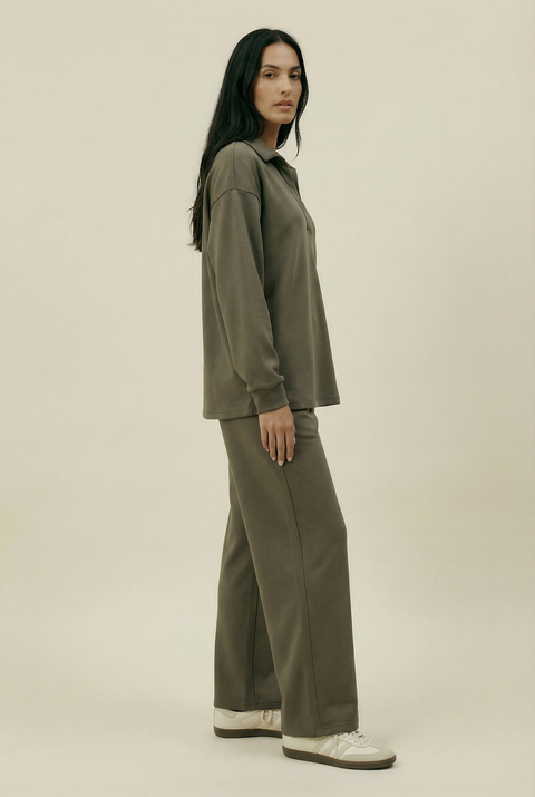 Woman wearing an olive green outfit on a beige background