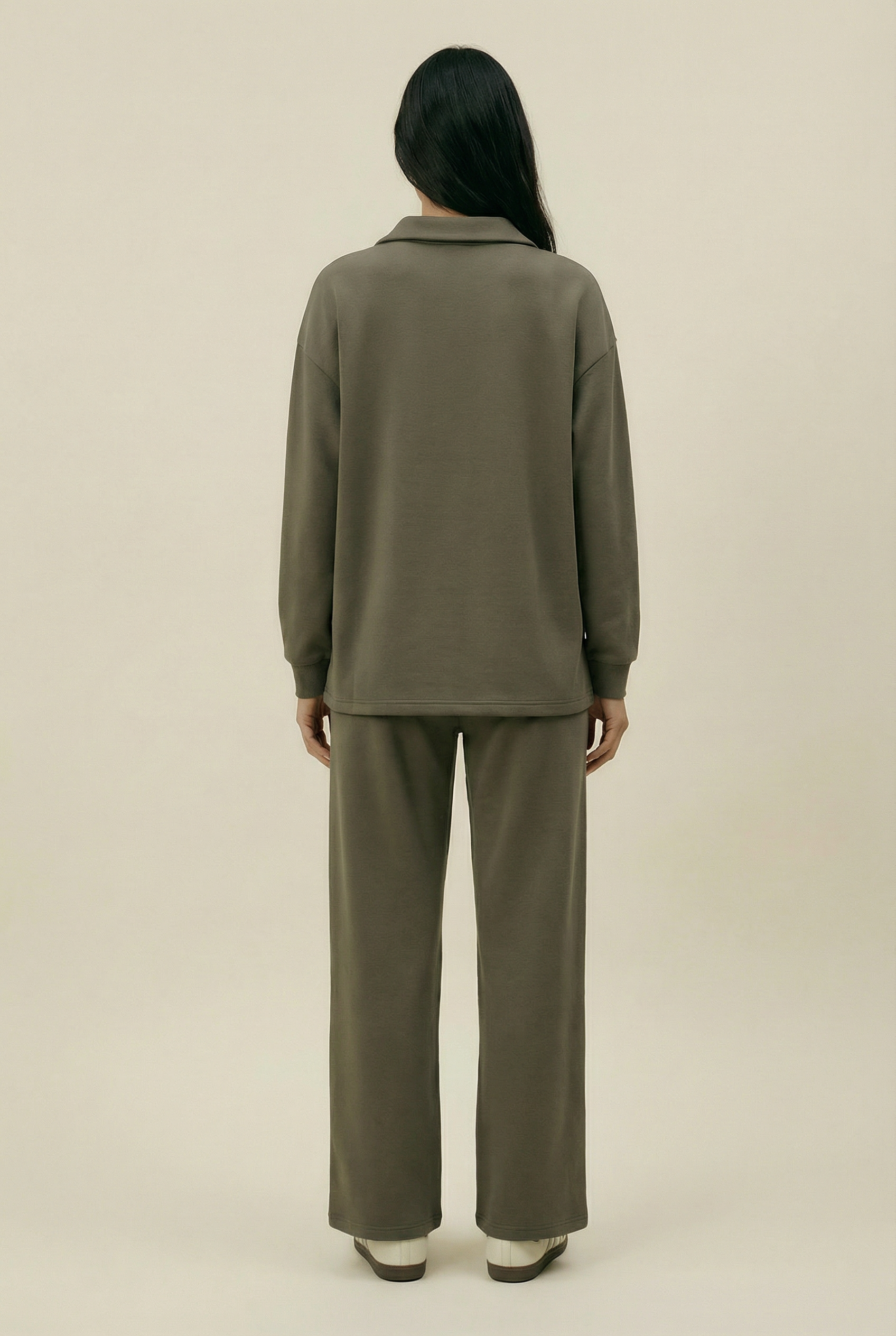 Person wearing a green outfit on a beige background