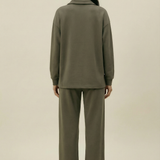 Person wearing a green outfit on a beige background