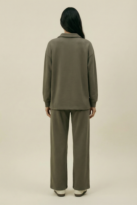 Person wearing a green outfit on a beige background